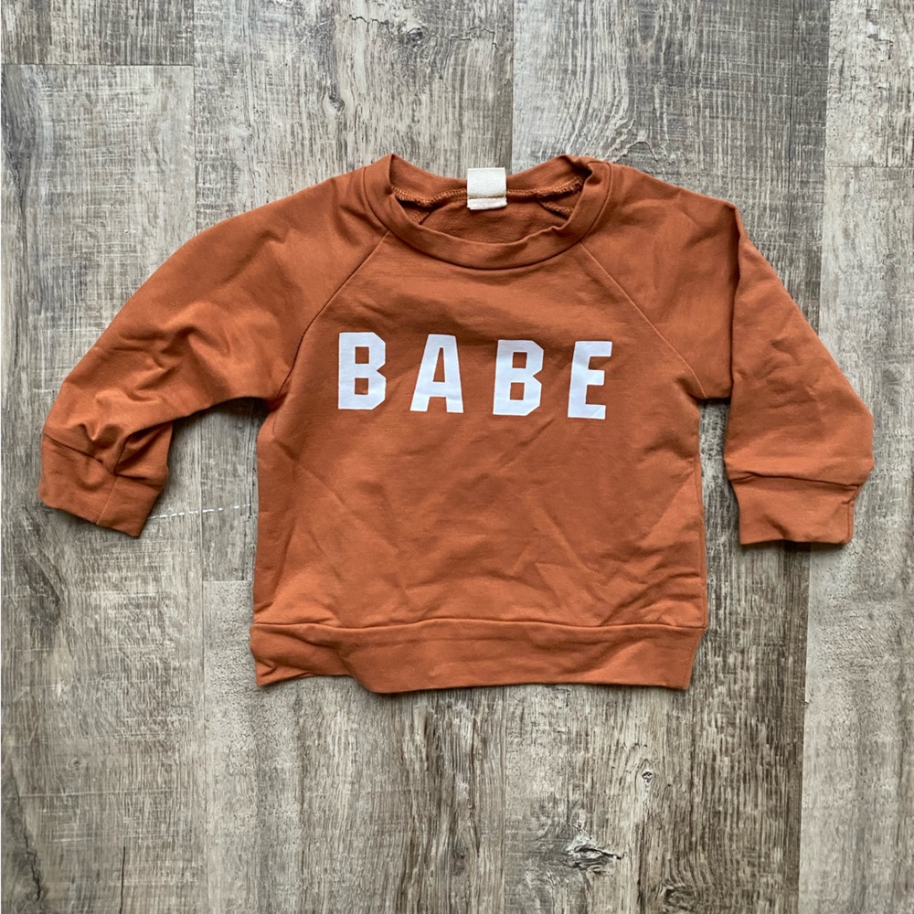 Baby sweater size 6 months. Rusty orange color. Could be gender neutral.